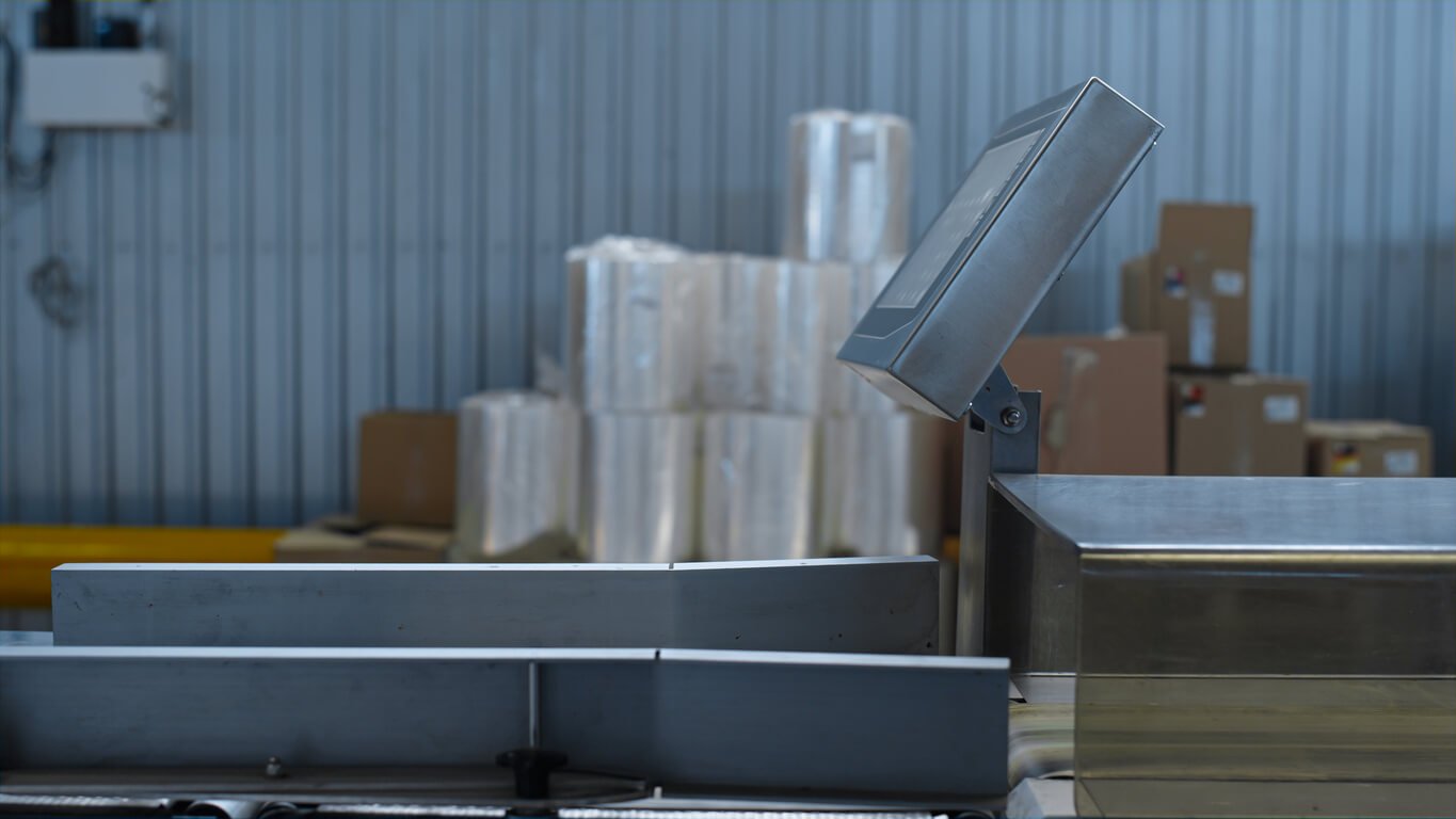 sideview of industrial scale with boxes stacked in the background